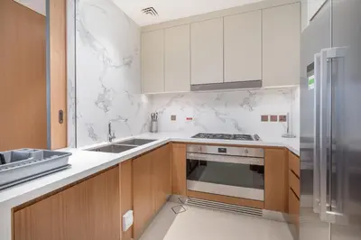 a kitchen with white counters and a stove top oven at Shukr شكر - Luxury 3BR with Panoramic Burj Khalifa & Fountain Views - Address Residence Dubai Opera - 2 Min Walk to Dubai Mall in Dubai