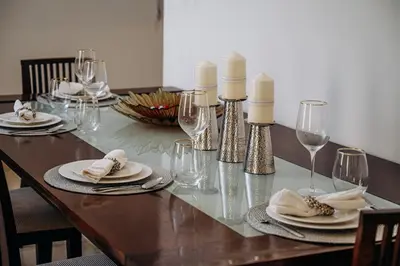 a wooden table with candles and plates and wine glasses at Top Holiday Location - Walk to Beach - Free Pool & Gym in Dubai