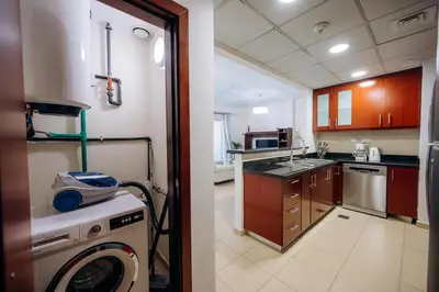 a kitchen with a washing machine and a sink at Top Holiday Location - Walk to Beach - Free Pool & Gym in Dubai
