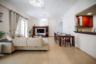 a living room with a couch and a dining room at Top Holiday Location - Walk to Beach - Free Pool & Gym in Dubai