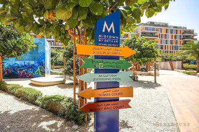 a street sign with many different signs on it at Cozy Studio With Style Midtown Retreat - Impz in Dubai