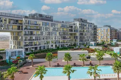 a large apartment building with a swimming pool and palm trees at Cozy Studio With Style Midtown Retreat - Impz in Dubai