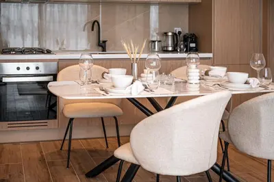 a kitchen with a table with chairs and wine glasses at Brand New 2BR -Spacious in Dubai