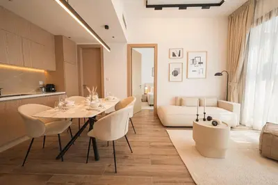 a living room with a table and chairs and a couch at Brand New 2BR -Spacious in Dubai