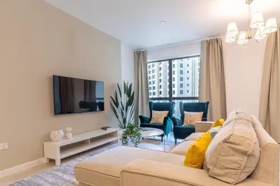 a living room with a couch and chairs and a tv at The Smart Concierge - Murjan in Dubai