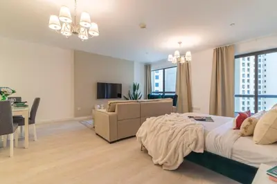 a bedroom with a bed and a living room at The Smart Concierge - Murjan in Dubai