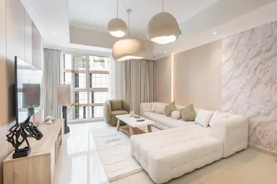 a living room with a white couch and a tv at Amal أمل Cozy City Apt 3BD with balconies, 1 min walk to Dubai Mall- Dar Samita Holiday Homes in Dubai