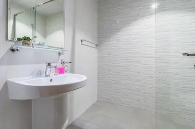a white bathroom with a sink and a shower at Amal أمل Cozy City Apt 3BD with balconies, 1 min walk to Dubai Mall- Dar Samita Holiday Homes in Dubai