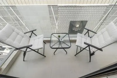 three chairs and a table in a room at Amal أمل Cozy City Apt 3BD with balconies, 1 min walk to Dubai Mall- Dar Samita Holiday Homes in Dubai