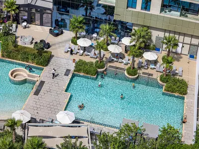 an overhead view of a large swimming pool with umbrellas at Livin' Holiday - Studio - Cozy Flat in Business Bay in Dubai