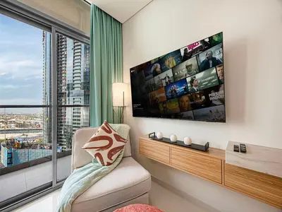 a living room with a large window and a tv at Livin' Holiday - Studio - Cozy Flat in Business Bay in Dubai