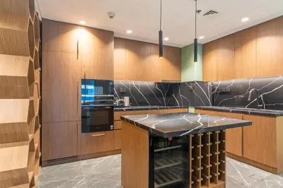 a kitchen with wooden cabinets and a black counter top at The Smart Concierge - Elite Residence in Dubai