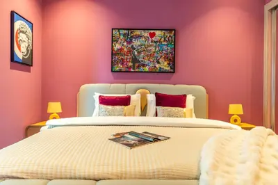 a bedroom with a large bed with pink walls at The Smart Concierge - Elite Residence in Dubai