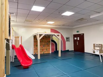 a childrens playroom with a red slide in a room at The Smart Concierge - Elite Residence in Dubai