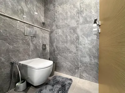 a bathroom with a white toilet in a room at Golden Glow Getaway 1BR in JVC in Dubai