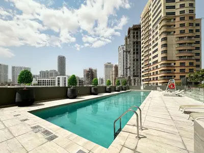 a swimming pool on the roof of a building at Golden Glow Getaway 1BR in JVC in Dubai