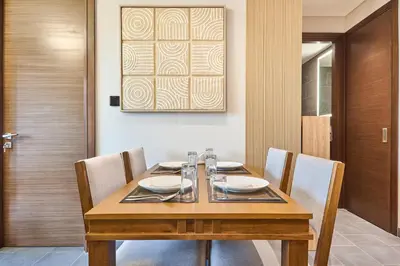 a dining room with a wooden table and chairs at STAY BY LATINEM Luxury 1BR Holiday Home CB 1008 Near Burj Khalifa in Dubai