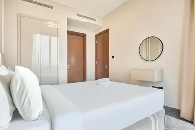 a bedroom with a white bed and a mirror at STAY BY LATINEM Luxury 1BR Holiday Home CB 1008 Near Burj Khalifa in Dubai