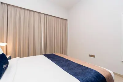 a bedroom with a white bed with a blue blanket at CitiHome Stylish Design Prime Location in Dubai