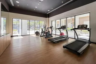 a gym with several treadmills and elliptical machines at Elegant 1 Bed Creek Beach Stay with Beach Access in Dubai