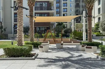 a park with a swing and palm trees at Elegant 1 Bed Creek Beach Stay with Beach Access in Dubai