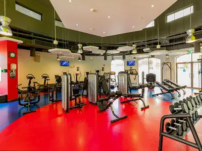 a gym with cardio equipment on a red floor at dreams stay in Dubai