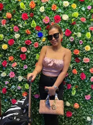 a woman standing in front of a wall of flowers at dreams stay in Dubai