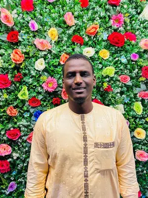 a man standing in front of a wall of flowers at dreams stay in Dubai