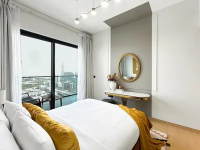 a bedroom with a large bed and a mirror at Modern 1BR Haven in Prime JVC Spot in Dubai