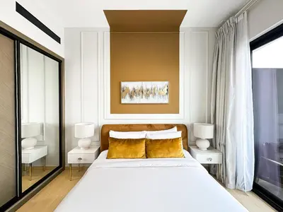 a bedroom with a large white bed with yellow pillows at Modern 1BR Haven in Prime JVC Spot in Dubai