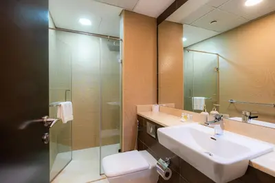 a bathroom with a sink and a glass shower at Cozy - Accessible to Tram - Convenient in Dubai