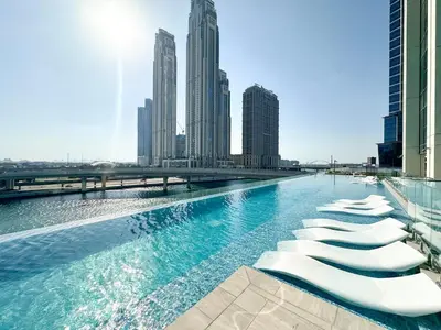 a pool in the middle of a city with tall buildings at FIRST CLASS 2BR Luxury Canal & Pool Views in Dubai