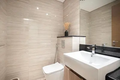 a bathroom with a white sink and a toilet at FIRST CLASS 2BR Luxury Canal & Pool Views in Dubai