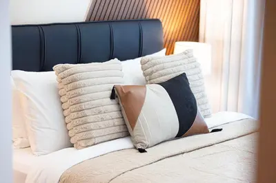 a bed with white pillows on top of it at FIRST CLASS 2BR Luxury Canal & Pool Views in Dubai