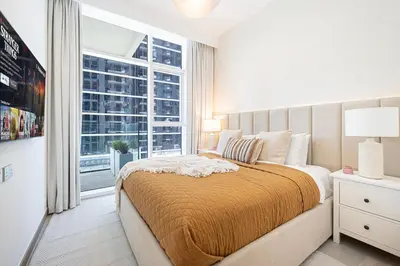 a bedroom with a bed and a large window at FIRST CLASS 2BR Luxury Canal & Pool Views in Dubai