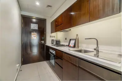 a kitchen with wooden cabinets and a sink at GuestReady - City Nest | Balcony | Majestine Tower in Dubai