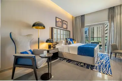 a bedroom with a bed and a desk and a chair at GuestReady - City Nest | Balcony | Majestine Tower in Dubai