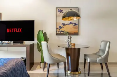a room with a table and two chairs and a tv at GuestReady - City Nest | Balcony | Majestine Tower in Dubai