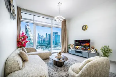 a living room with a couch and a tv at Elegant 1BHK Metro Access & Trade Centre in Dubai