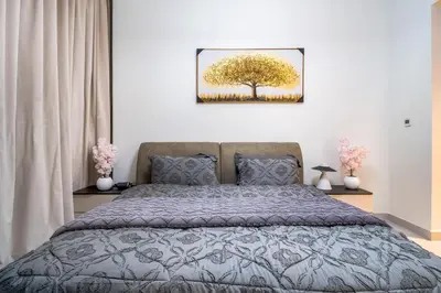 a bedroom with a bed and a picture of a tree at Elegant 1BHK Metro Access & Trade Centre in Dubai