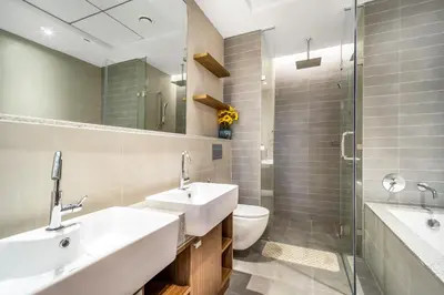 a bathroom with two sinks and a toilet and a mirror at Elegant 1BHK Metro Access & Trade Centre in Dubai