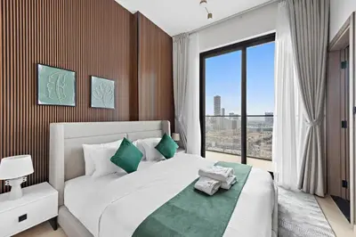 a bedroom with a large bed with a large window at Cozy 1BR Apartment with Pool & Parking JVC Dubai in Dubai