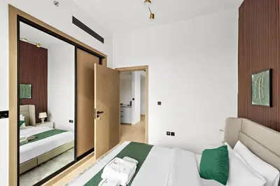 a bedroom with a bed and a large mirror at Cozy 1BR Apartment with Pool & Parking JVC Dubai in Dubai