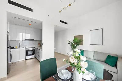 a white living room with a couch and a table at Cozy 1BR Apartment with Pool & Parking JVC Dubai in Dubai