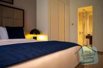 a bedroom with a large bed with a blue blanket at Burj Khalifa View - Cozy 1BR - Pool - Gym - Spa in Dubai