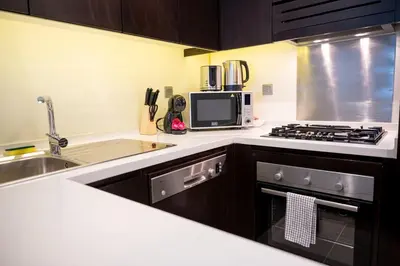 a kitchen with a sink and a stove top oven at Burj Khalifa View - Cozy 1BR - Pool - Gym - Spa in Dubai