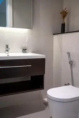 a bathroom with a white toilet and a sink at Burj Khalifa View - Cozy 1BR - Pool - Gym - Spa in Dubai