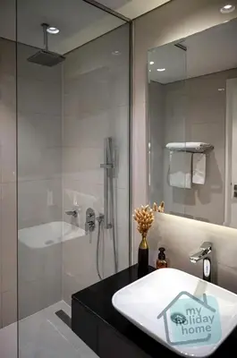 a bathroom with a sink and a glass shower at Burj Khalifa View - Cozy 1BR - Pool - Gym - Spa in Dubai
