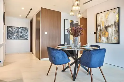 a dining room with a table and blue chairs at STAY BY LATINEM Luxury 2BR Holiday Home CVG 807 Near Downtown in Dubai