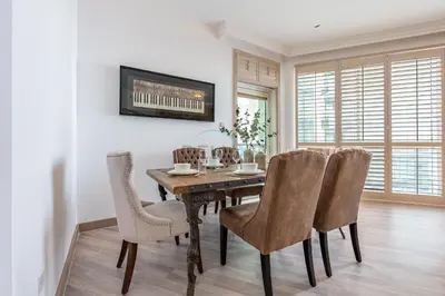 a dining room with a wooden table and chairs at Walking Distance to Bluewaters Island, with The Walk JBR right at your Door and Private Beach Access, Al Bateen Residences, JBR by Deluxe Holiday Homes in Dubai